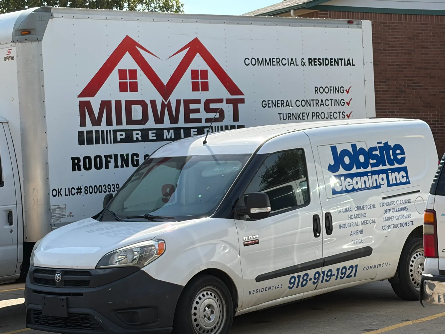 The Midwest Premier Roofing box truck and the Jobsite Cleaning Inc. van parked together in Tulsa